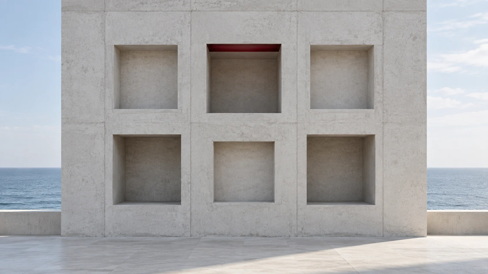 A concrete wall seen square on, with six equal square niches in two rows, alike but for a line of ruby light in the top of one; the sea on either side.