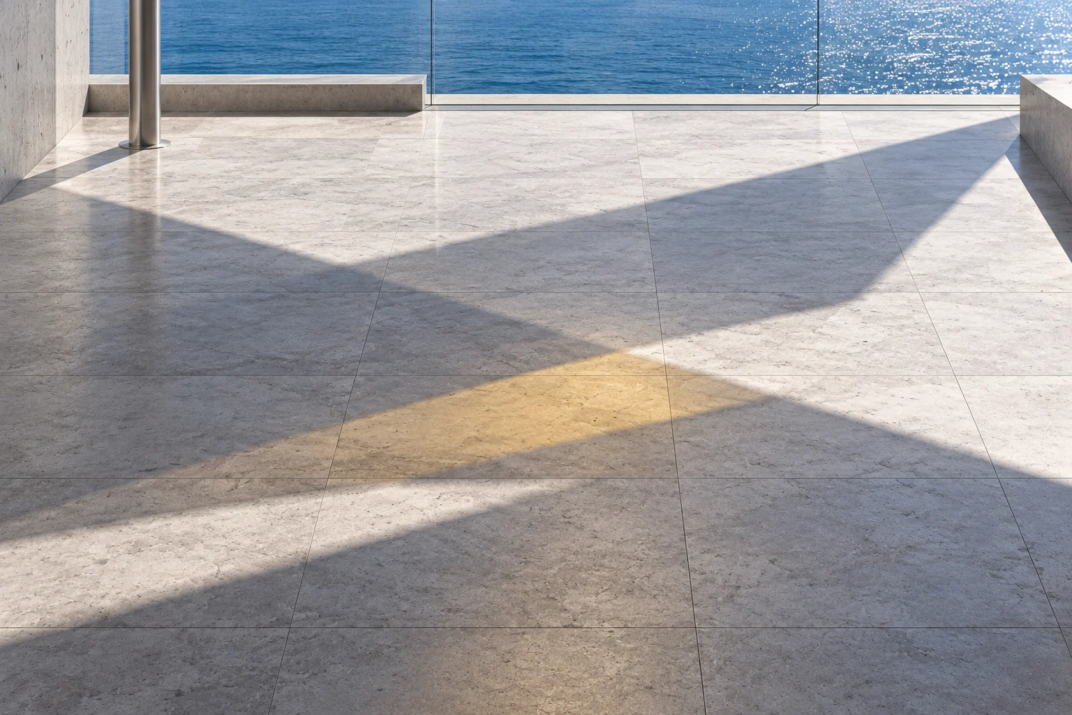 The stone court floor crossed by overlapping shadows, lighter where one falls and deeper where two do, with a strip of citrine light where they all cross; the sea beyond the rail.